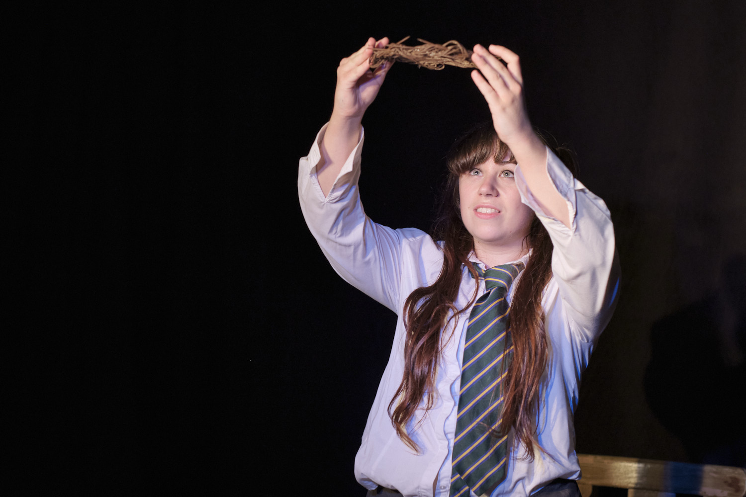 A girl in school uniform raises a crown of thorns. Image from 'The True Story Of The Little Girl Who Thought She Was The Second Coming Of Jesus Christ'
