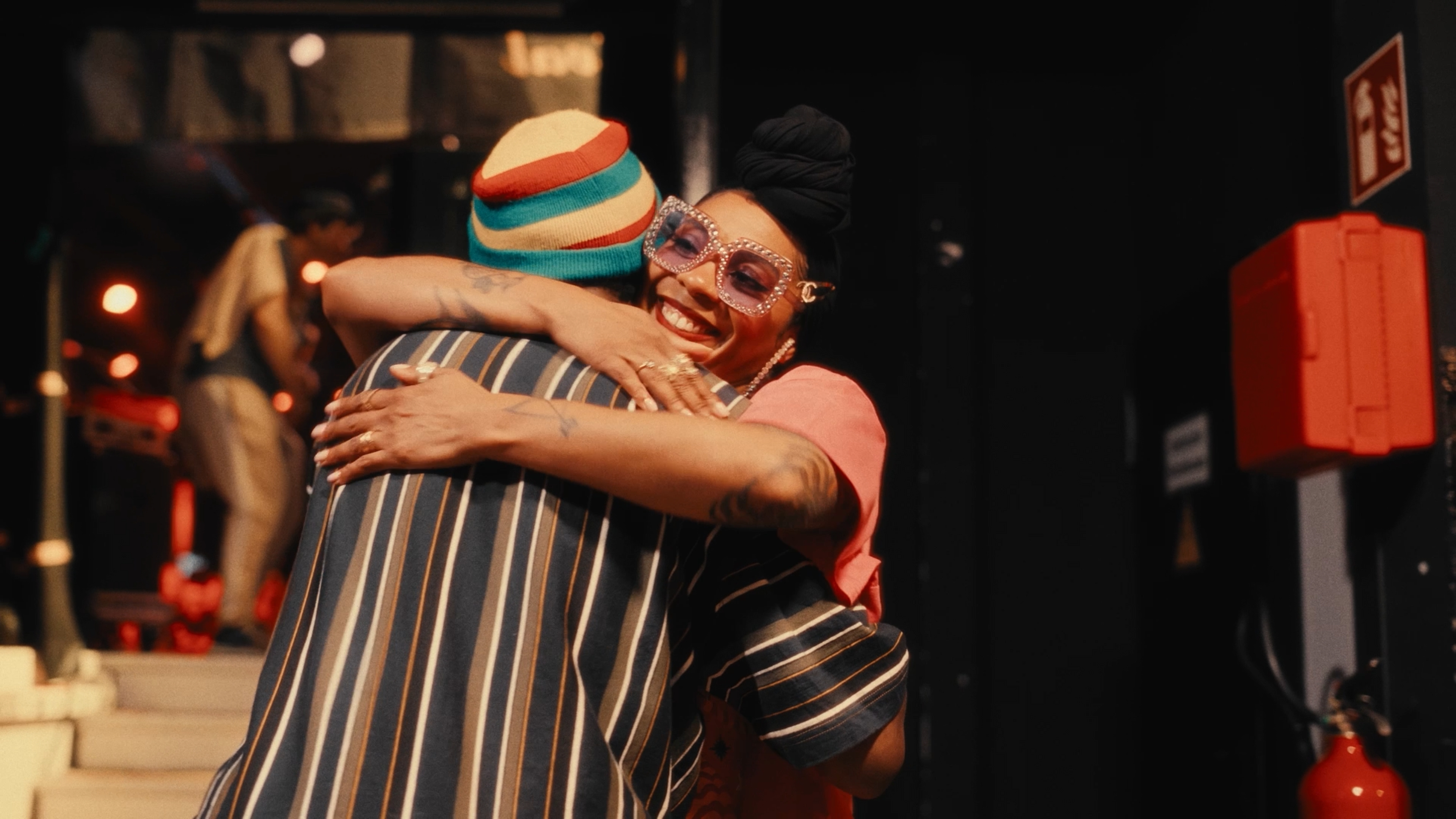 Singer smiling during a backstage embrace