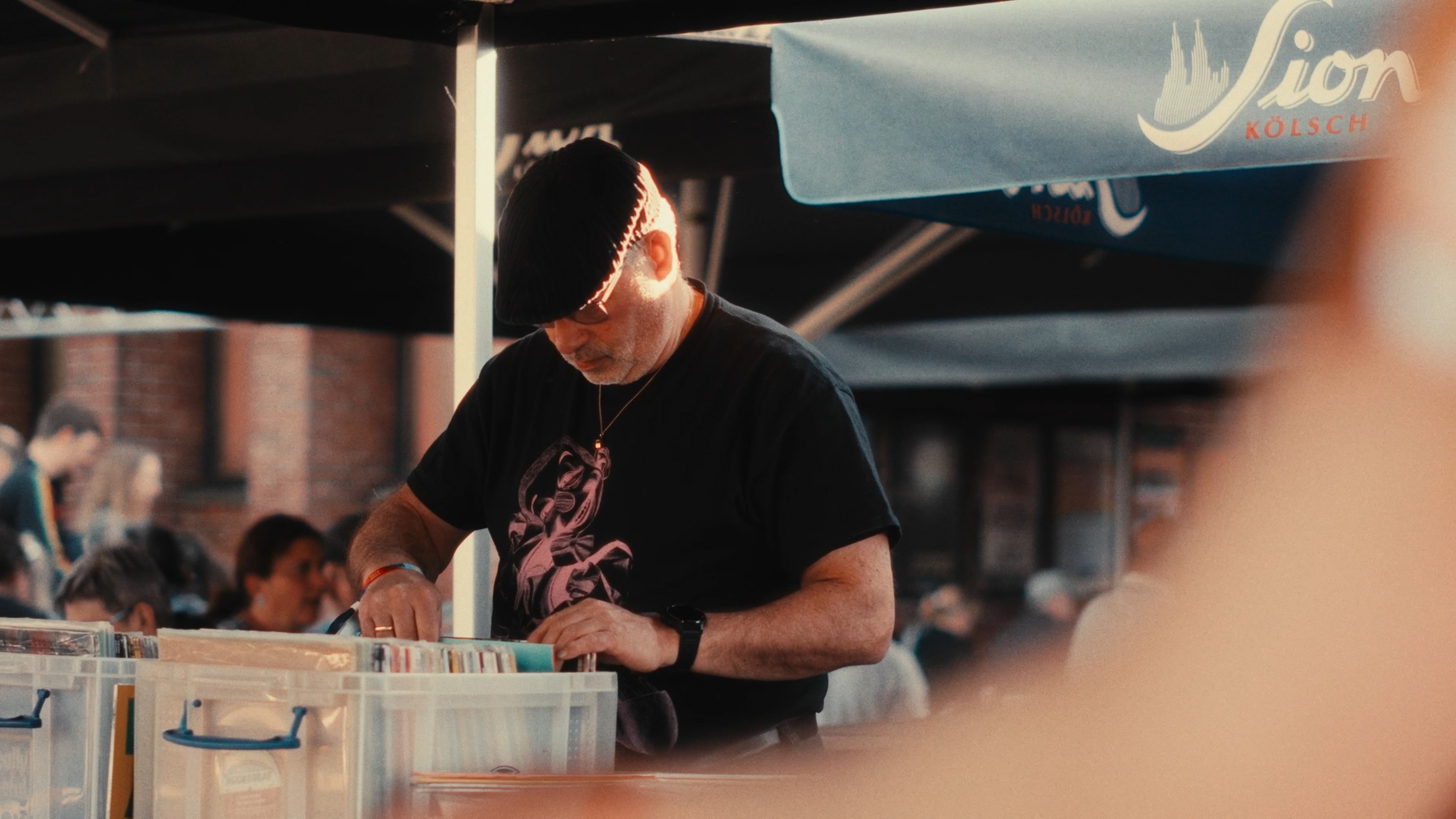 Festival visitor browsing vinyl records at an outdoor stall