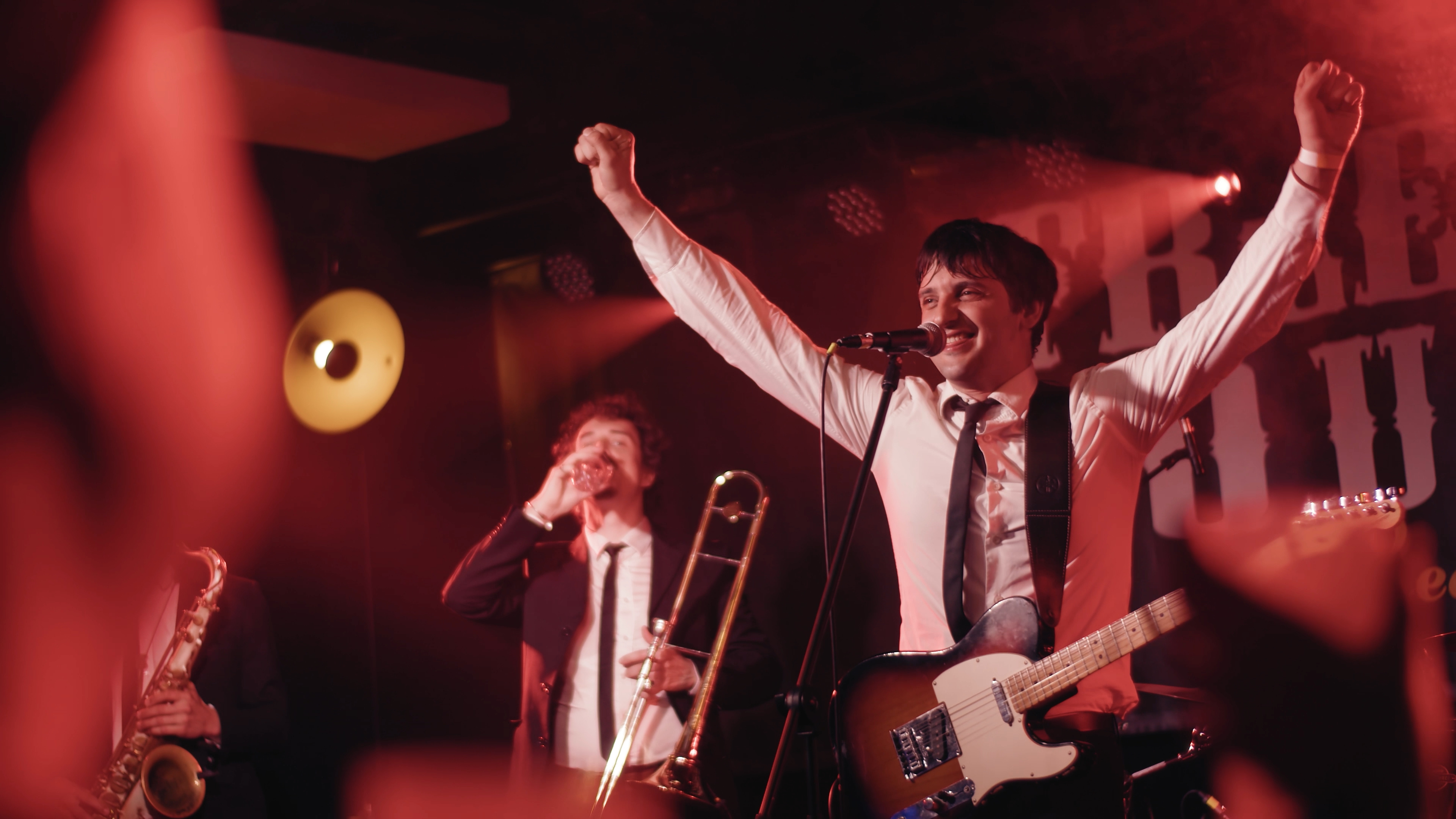 Guitarist raising his arms during a live performance